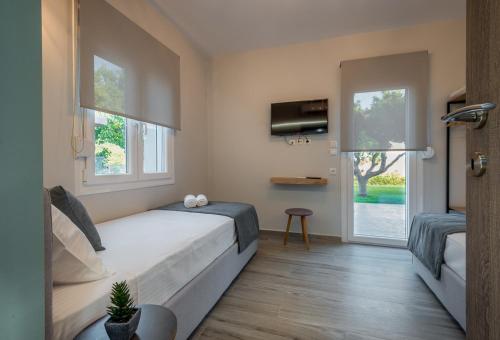 - une chambre avec un lit, une télévision et 2 fenêtres dans l'établissement Casa Rafaela 201, à Prévéza