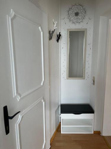 a hallway with a mirror and a door with a bench at BacherlHouse - Apt Miglbach in Schörfling