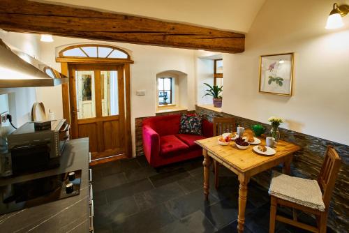 a living room with a red couch and a table at Baroque chaplain house Kaplanka 1796 A. D. - historical luxury apts in Bohemian Paradise in Železný Brod