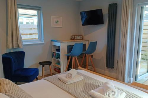 a bedroom with a bed and two chairs and a desk at Stylish coastal retreat in St Ives with parking in St Ives