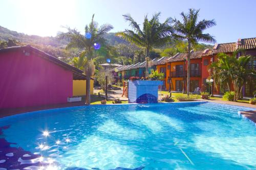 a large swimming pool in front of some houses at Chalés Saint Germain in Florianópolis