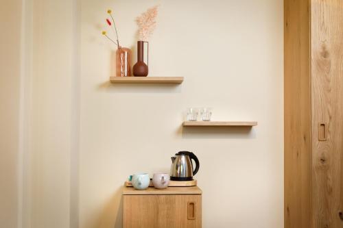 a table with a tea kettle and cups on it at Hotel Das Regensburg in Regensburg