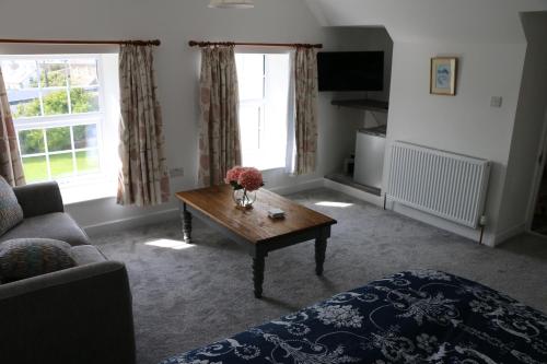 a living room with a coffee table in front of a window at Ty Nant Little Haven in Little Haven