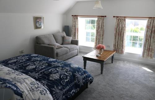 a bedroom with a bed and a couch and a table at Ty Nant Little Haven in Little Haven