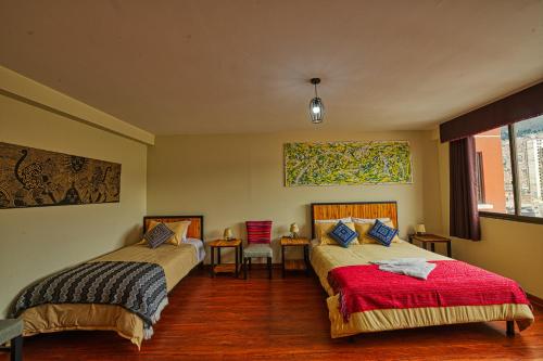 a bedroom with two beds and a table and chairs at ISKAY BOUTIQUE HOSTEL in La Paz
