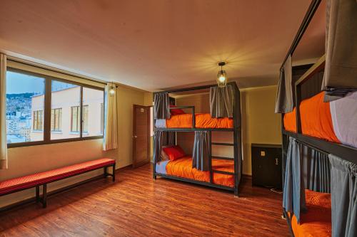 a room with three bunk beds and a window at ISKAY BOUTIQUE HOSTEL in La Paz