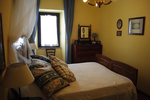 a bedroom with a bed with pillows and a window at The garden of history in Bolsena