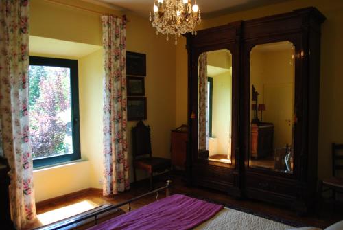 1 dormitorio con espejo grande y lámpara de araña en The garden of history en Bolsena