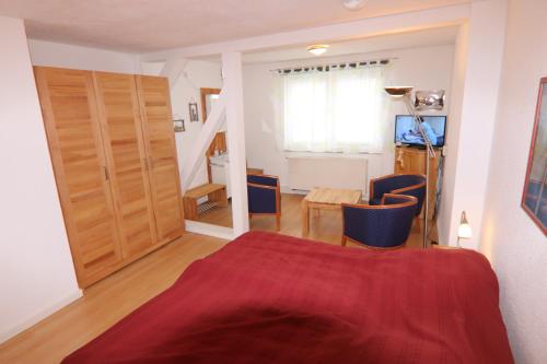 a bedroom with a bed with a red blanket at Landhaus Schlossblick in Sangerhausen