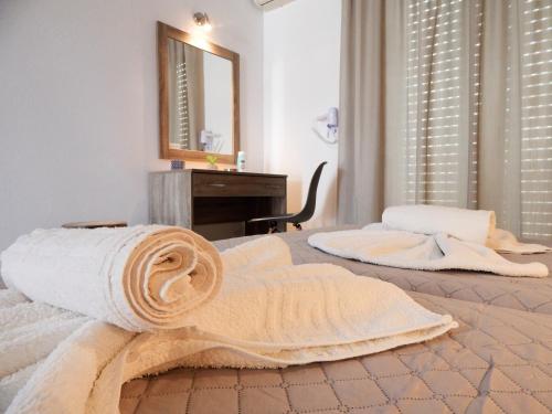a bedroom with two beds with towels and a mirror at POLITIS STUDIOS in Kefalos