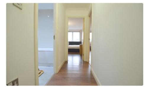 un couloir avec une porte s'ouvrant sur une chambre dans l'établissement Spacious modern flat in Luton town centre, à Luton