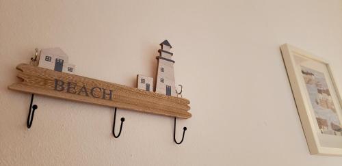 a wooden shelf on a wall with a lighthouse at Stunning sea views apartment, pool, 5 min walk to beach, Winner of 2025 Travellers Choice award in Arenal d'en Castell