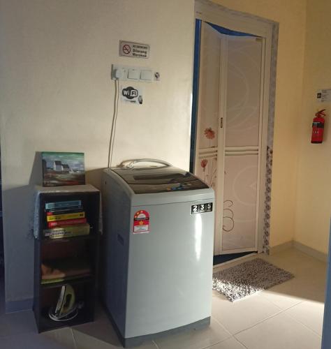 a small refrigerator in a room next to a door at Topville Homestay in Kangar