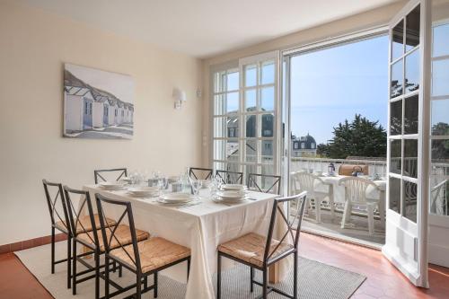 une salle à manger avec une table et des chaises et une grande fenêtre dans l'établissement Villa à Pornic à 100m de la Plage, à Pornic