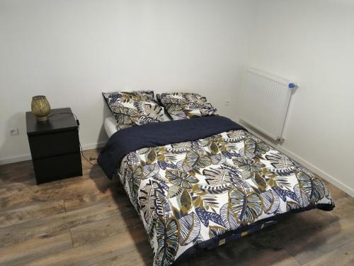 ein Schlafzimmer mit einem Bett mit einer Bettdecke in der Unterkunft Etage privatif tout confort dans une maison in Conflans-Sainte-Honorine
