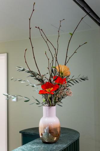 a vase with flowers in it on a table at Hotel Das Regensburg in Regensburg