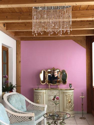 comedor con paredes de color púrpura y lámpara de araña en Haus bei der Linden Ferienwohnungen, en Schwangau