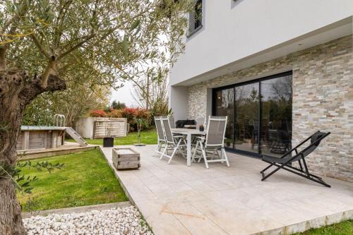 a patio with a table and chairs in a yard at Les Arènes in Dax