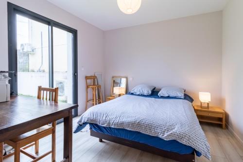 een slaapkamer met een bed, een bureau en een raam bij Les Arènes in Dax