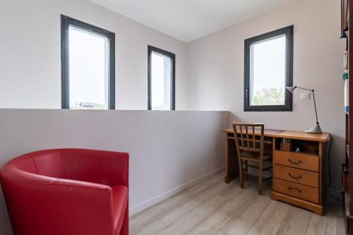 a living room with a desk and a red chair at Les Arènes in Dax