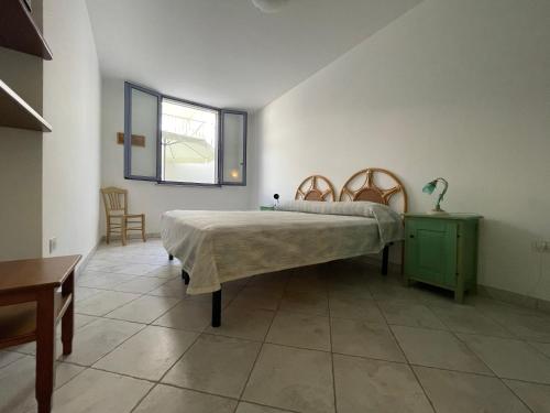 um quarto com uma cama, uma mesa e uma janela em La Luna em Leuca