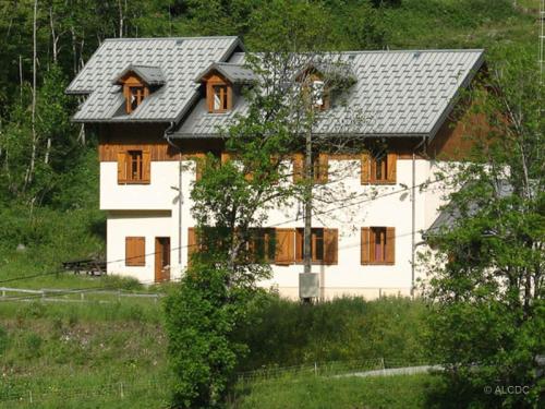 une maison blanche avec un toit gris sur une colline dans l'établissement Centre de vacances Les Moulins, 
