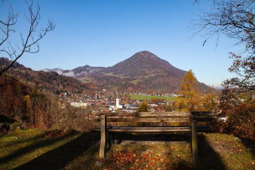 a bench on a hill with a view of a city at Ferienwohnung Bergblick in Oberaudorf
