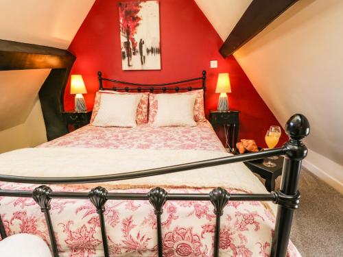 a bedroom with a bed with a red wall at Black Gem Cottage in Whitby