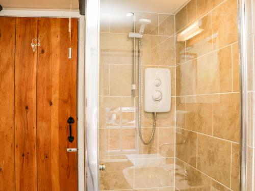 a bathroom with a shower with a glass door at Black Gem Cottage in Whitby