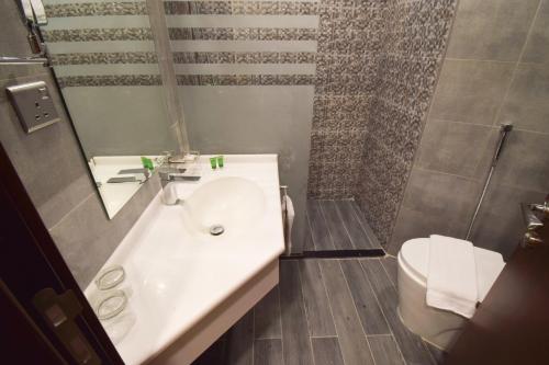 a bathroom with a sink and a shower and a toilet at Emaar Elite Hotel in Makkah
