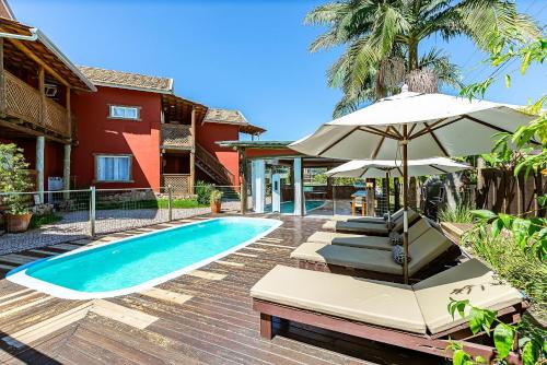 a villa with a swimming pool and a house at Lindo condomínio em meio à natureza em Bombinhas VLE in Bombinhas
