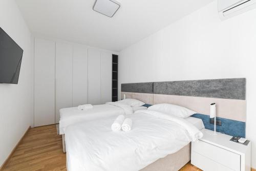 a bedroom with two beds with white sheets at Fontana Residence Budva in Budva
