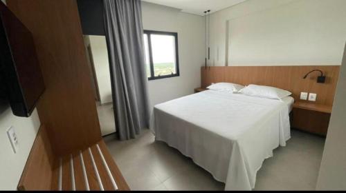 Salinas premium Resort في سالينوبوليس: غرفة نوم بسرير ابيض ونافذة
