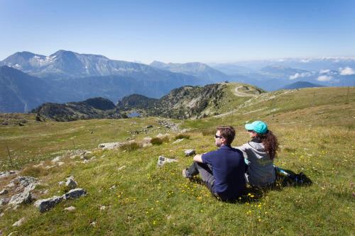 a man and woman sitting on top of a mountain at Résidences Les Villages du Bachat (by Popinns) in Chamrousse