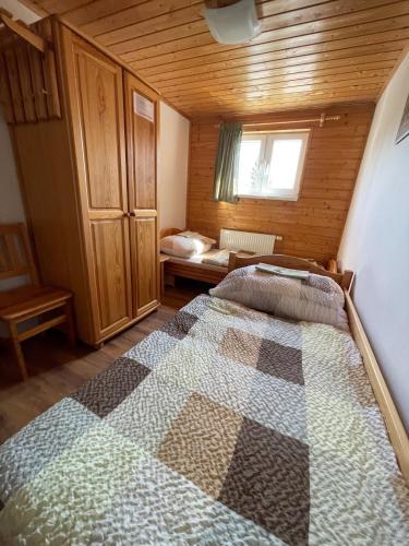 a bedroom with a bed in a wooden room at Inovecká Chata in Trenčianske Jastrabie