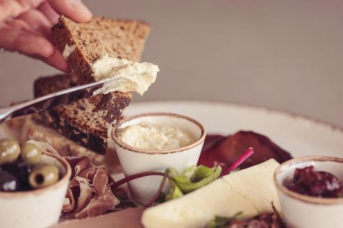 a plate of food with a person cutting a sandwich at Longlands Inn & Cottages in Carnforth