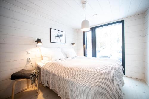 1 dormitorio con cama blanca y ventana grande en Villa Dakota, en Syöte