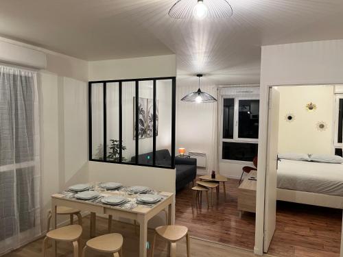 Habitación con mesa, sillas y cama en Cosy Appart Disney-Paris / RER Val d’Europe à 150m, en Montévrain