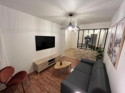 a living room with a couch and a flat screen tv at Cosy Appart Disney-Paris / RER Val d’Europe à 150m in Montévrain