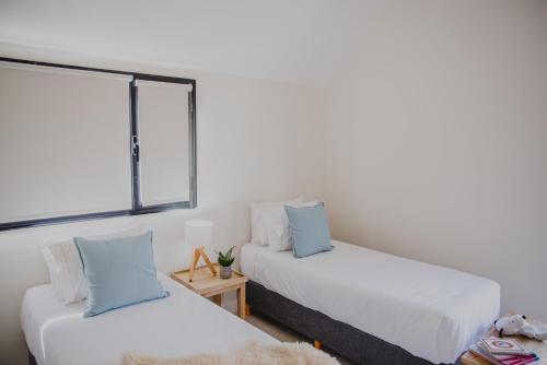 two beds in a room with a window at El Coiron Aparts in Esquel