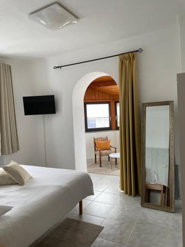 a bedroom with a bed and a mirror and a chair at Camere Villa Lunardini in Frassinetto