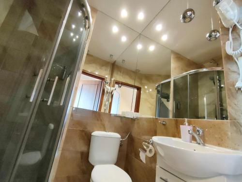 a bathroom with a toilet and a sink and a shower at Hotel Viwaldi in Baruchowo