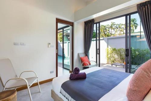 a bedroom with a large bed and a balcony at Villa Crystal Two-bedroom private pool villa in Phuket