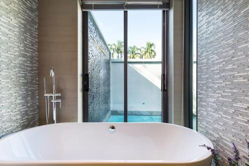 a bath tub in a bathroom with a large window at Villa Crystal Two-bedroom private pool villa in Phuket