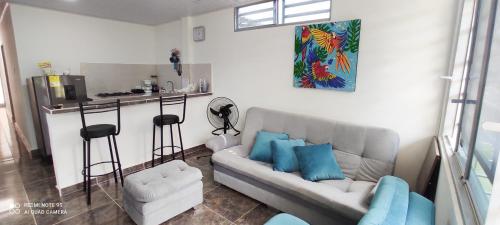 ein Wohnzimmer mit einem Sofa und einer Küche in der Unterkunft Hermoso apartamento con servicios y garaje. in Florencia