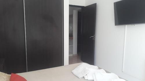 a bedroom with a black closet and a bed with towels at Departamentos VM in Villa María