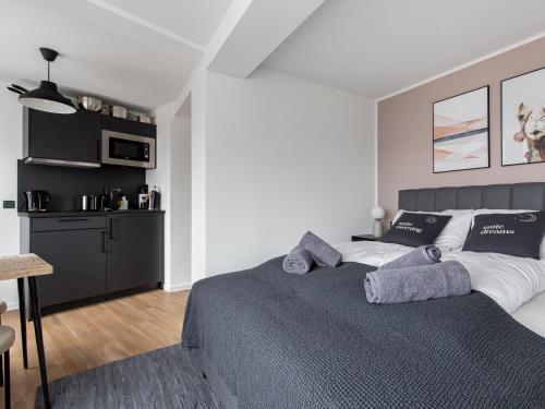 a bedroom with a large bed and a kitchen at Limehome Essen Kettwiger Straße in Essen