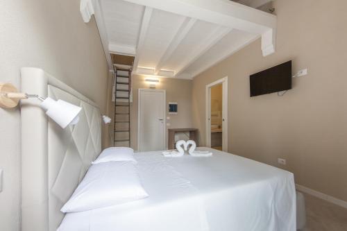 a white bed with two white towels on it at Relais Borgo Camisa in Castiadas