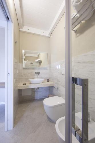 a bathroom with a white toilet and a sink at Relais Borgo Camisa in Castiadas