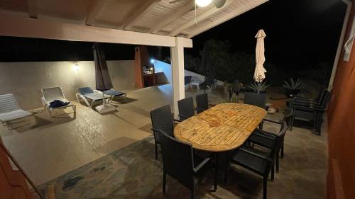 - une table à manger et des chaises sur la terrasse la nuit dans l'établissement Corse Villa Porticcio vue Mer, à Porticcio